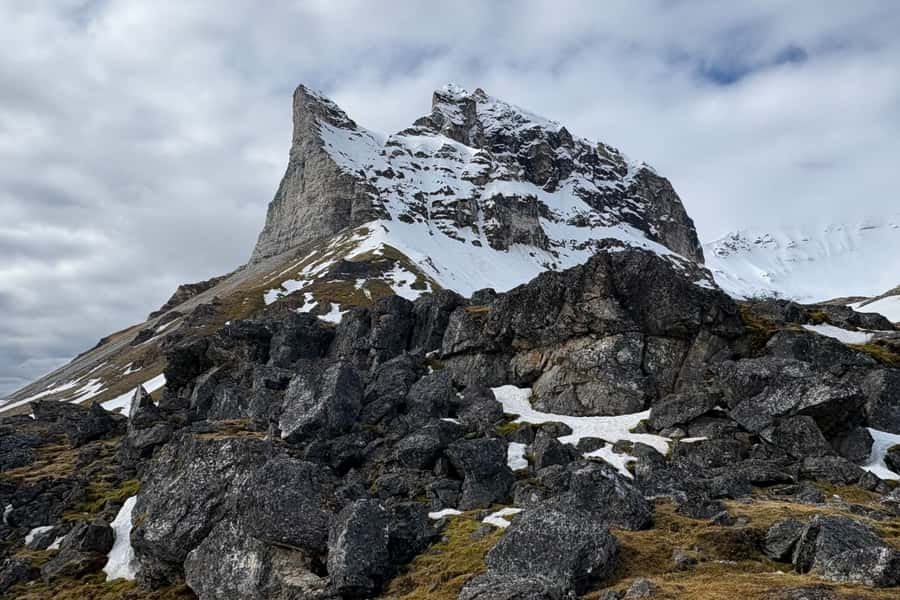 Schroffer Felsgipfel mit Schneeresten über der Tundra am Isfjord, Spitzbergen